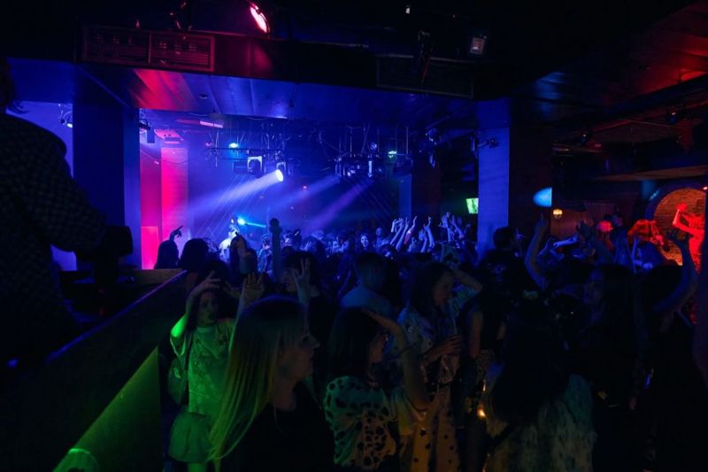 Klub w niebieskim świetle, tłum na parkiecie, ruchome głowy nad sceną